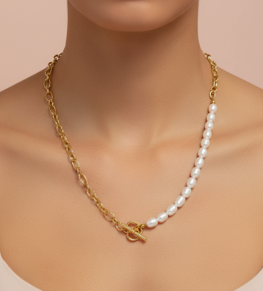 Gold chain necklace with a toggle clasp and pearl beads on a mannequin against a beige background