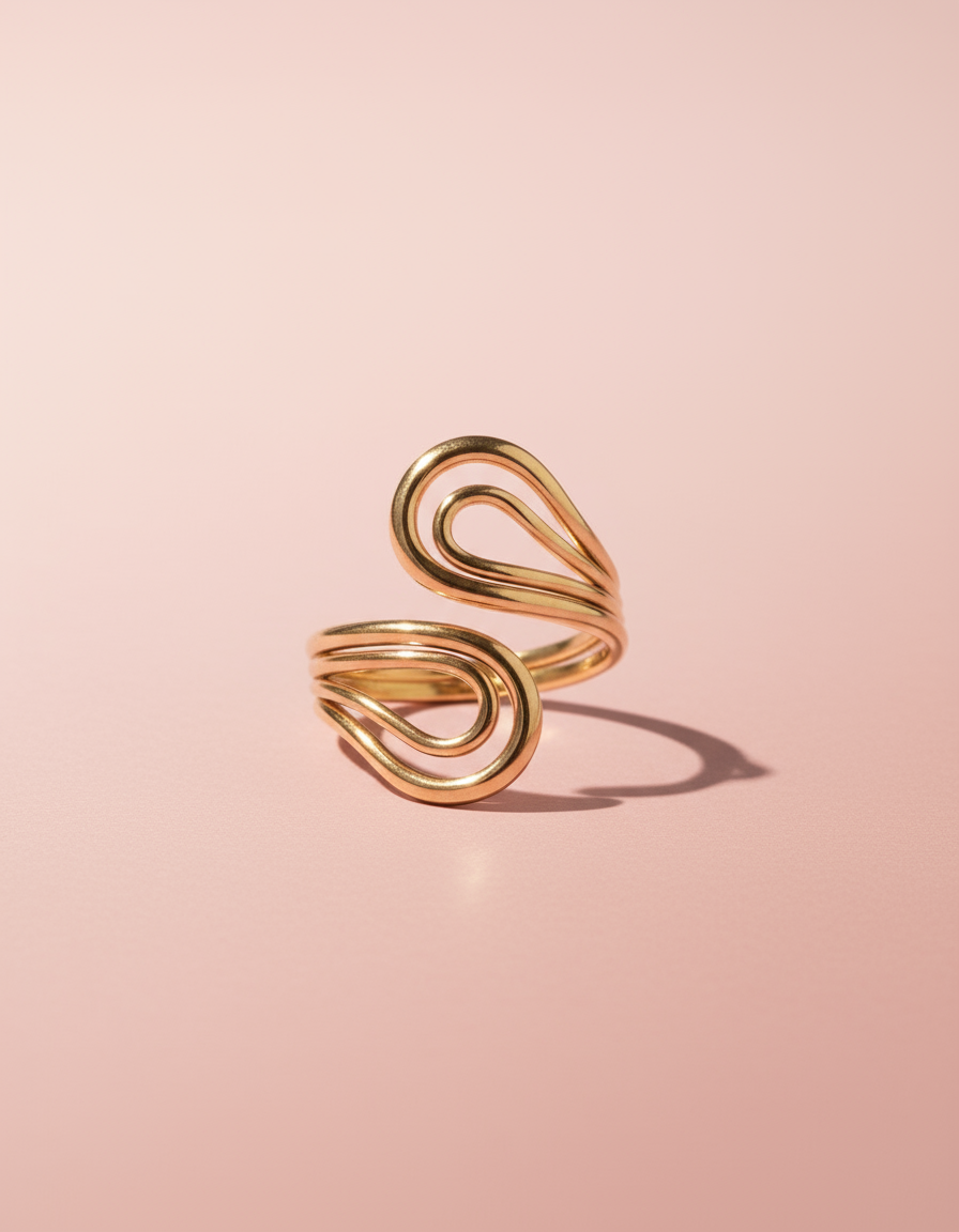 Gold spiral ring on a pink background