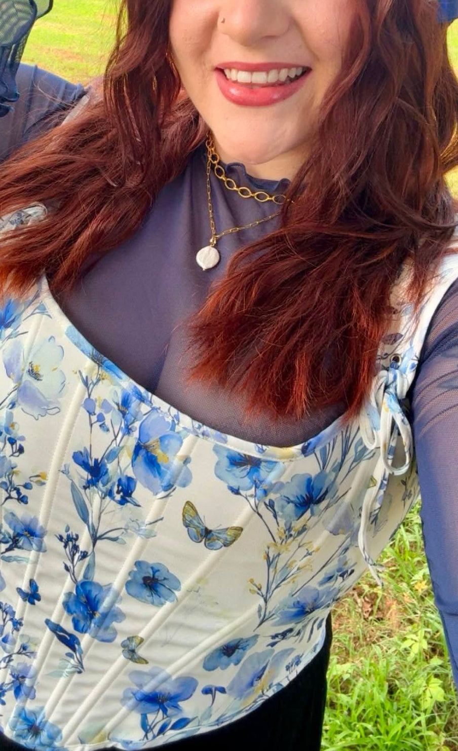 Woman wearing a blue floral headscarf and top outdoors