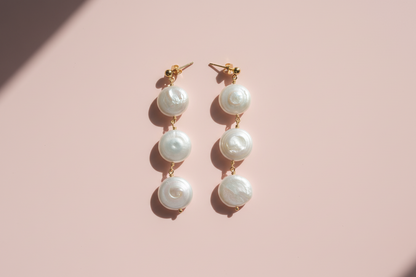 Pearl earrings on a pink background