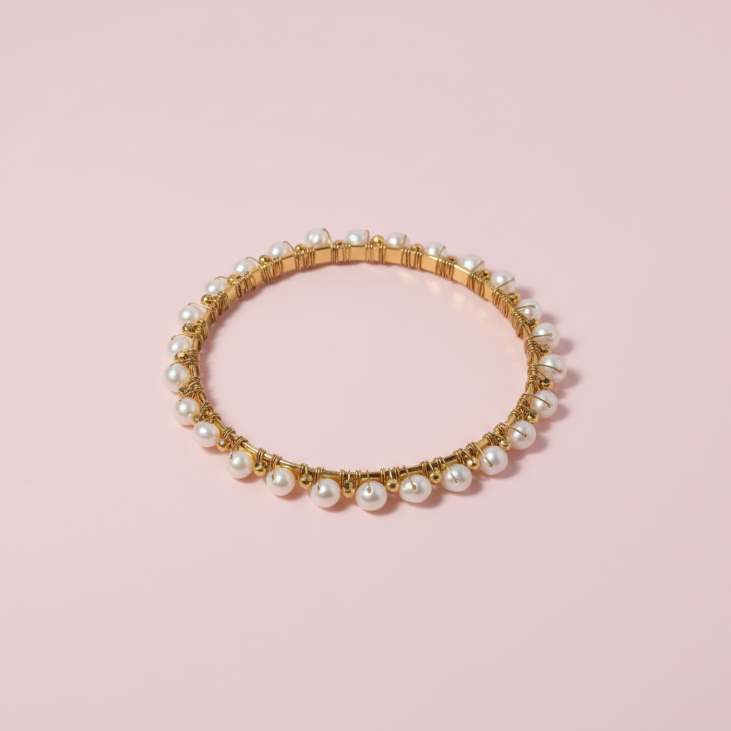 Gold and pearl bracelet on a white background