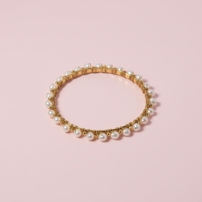 Gold and pearl bracelet on a white background