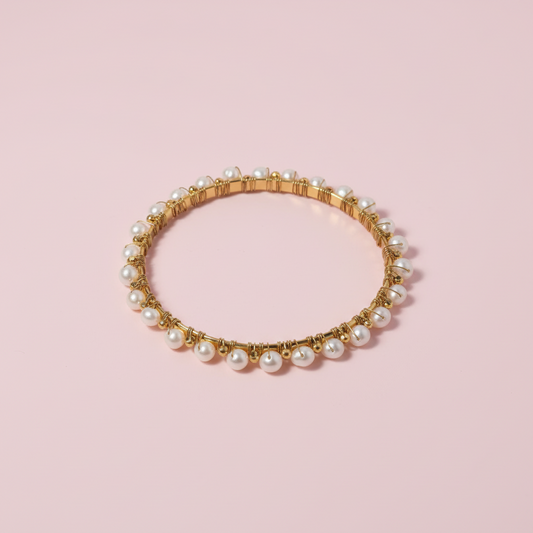 Gold and pearl bracelet on a white background
