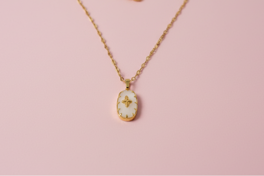 Gold necklace with a pendant on a pink background